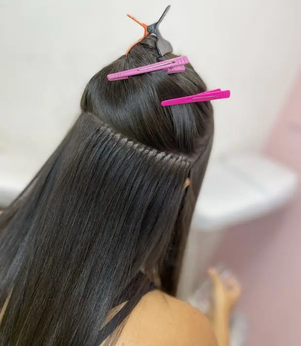A hand-sewn hair extension weft, seen up close
